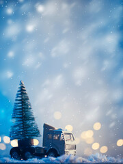 A toy truck transports a Christmas tree in a snowstorm copy space card