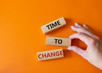 Time to change symbol. Concept word Time to change on wooden blocks. Businessman hand. Beautiful orange background. Business and Time to change concept. Copy space