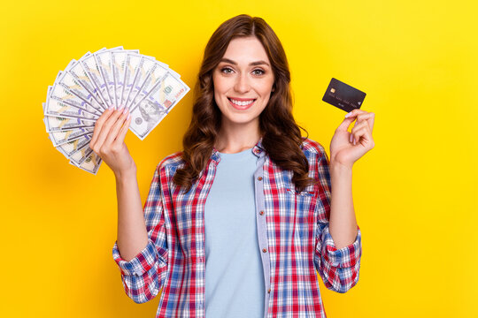Photo of sweet adorable lady wear plaid shirt rising plastic card dollars fan isolated yellow color background