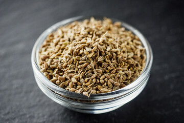 aromatic dry anise seeds on a dark black stone background