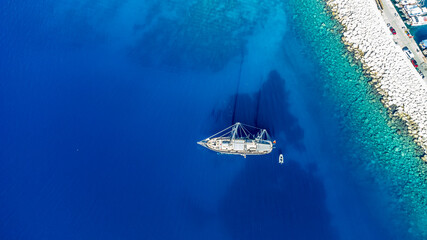 Drone footage of a boat in the cristal clear water of the ocean