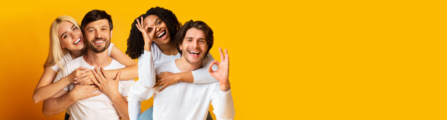 Two beautiful happy couple embracing on yellow