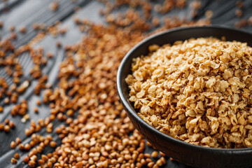 fresh raw buckwheat flakes on a black wooden background