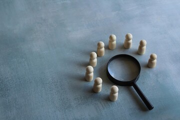 Wooden dolls and magnifying glass. Brainstorm, meeting, investigate, looking for solution concept