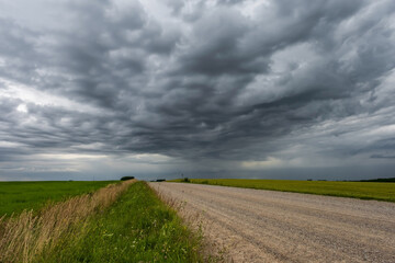 panorama of black sky background with storm clouds. thunder front over gravel road