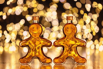 Bottles of homemade gingerbread syrup on light spotty background