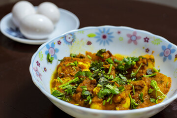 a delicious egg recipe garnished by coriander and two boiled eggs aside. Selective focus.