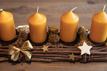 A candlestick with four candles stands on a beautiful wooden aged table
