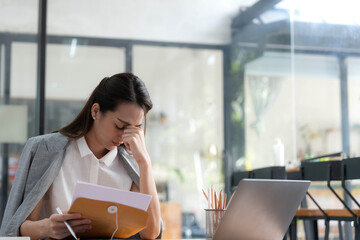 Young Business Asian women are stressed while working on laptop, Tired asian businesswoman with...