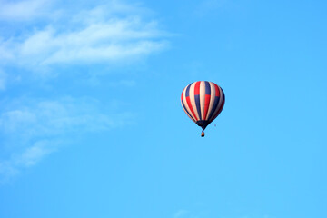 Fototapeta na wymiar hot air balloon in flight with a basket, blue white balloon red color