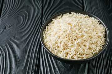 raw basmati rice on a black wooden background