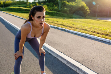 Shot of a sporty young woman catching her breath while exercising outdoors. Shot of a sporty young woman catching her breath while exercising outdoors