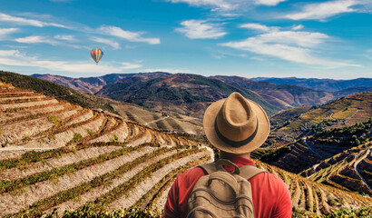Traveler man relaxing with a view of the Douro valley vineyards landscape - Port wine grapes © Armando Oliveira
