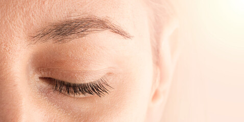 Obraz premium Beautiful female eyebrow and eyelashes. Part of the face close-up with space for text. The concept of cosmetics and make-up. copy space
