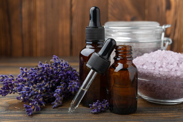 Obraz na płótnie Canvas Lavender flowers, fragrant sea salt and essential oils. The concept of spa, beauty and health salon, skin care cosmetics. Natural cosmetics.Aroma procedures. Closeup on brown texture background.