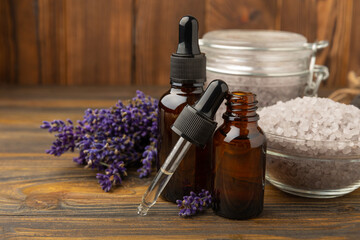 Lavender flowers, fragrant sea salt and essential oils. The concept of spa, beauty and health salon, skin care cosmetics. Natural cosmetics.Aroma procedures. Closeup on brown texture background.