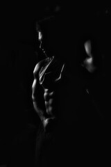 The athlete shows his body and abs, creative photo, black and white photo, contours, muscles stand...