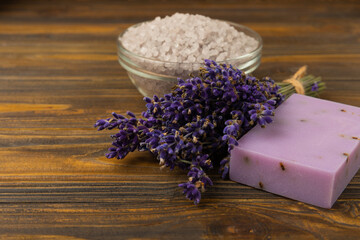 Obraz na płótnie Canvas Lavender flowers, fragrant sea salt and handmade soap. The concept of spa, beauty and health salon, skin care cosmetics. Natural cosmetics.Aroma procedures. Close up photo on white wooden background.
