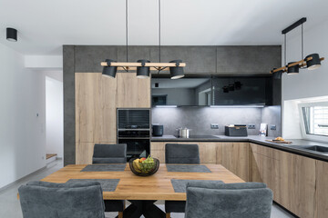 Dark kitchen with built in appliances in modern apartment