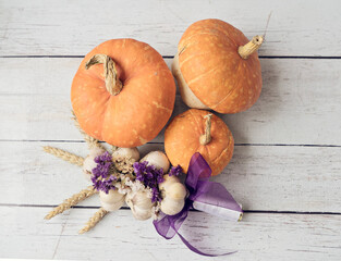 Tree decorative pumpkins with garlic in Thanksgiving compositions on wooden background, top view