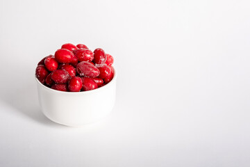 Frozen berry of fresh dogwood on a white, light background. Whole dogwood berries for compote