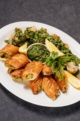 Assorted grilled fish with sauce. Decorated with lemon and herbs. Restaurant concept.