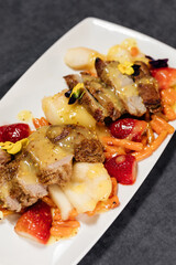 Baked duck breast with pear and carrot garnished with sweet sauce and strawberries. Restaurant concept.