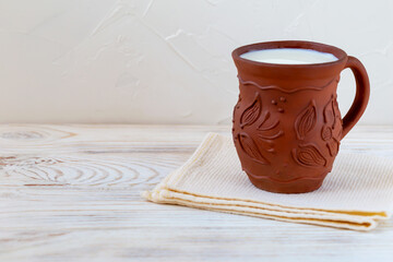 Fresh milk in a clay jug on a towel