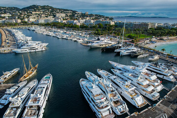 Aerial view of the marina of Cannes full of Yachts with la Croisette and La Plage Du Festival in...
