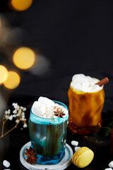 Christmas drinks. Couple of Viennese coffee glasess, macaroons, marshmallows, cinnamon and cardamom. Bokeh effect