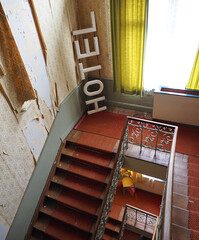 Lost Place Hotel with old Lettering in the Floor and hanging Wallpaper