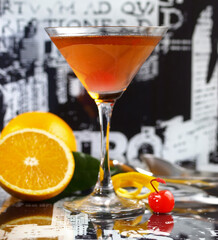 Manhattan Cocktail with Cherry and Orange Twist and City Bar Background