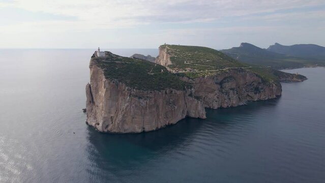 Aerial footage of Capo Caccia cliff with a lighthouse on the top in Sardinia, Italy
