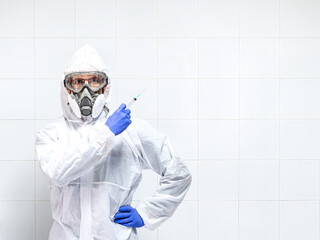 scientist with protective equipment showing a syringe