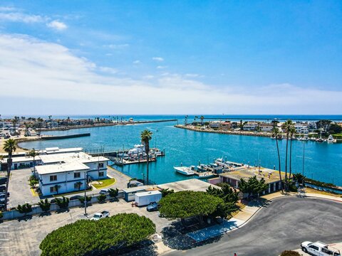 Fototapeta Drone view of Seabridge Oxnard in Channel Islands Harbor boats with tranquil water under blue sky