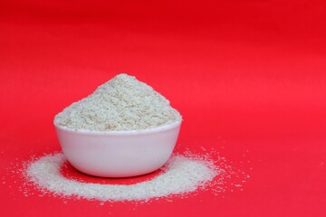 Closeup of Isabgol Husk or Psyllium Husk in a White Bowl Isolated on Red Background with Copy Space for Texts Writing