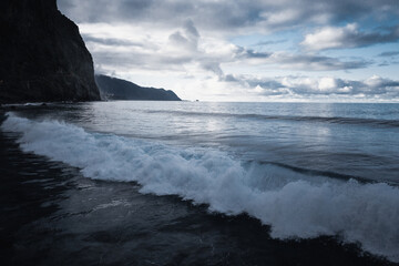 Amazing scenic view from a madeira trip at amazing sunsetlight in the mountsina with a view down to the sea in a moody and foggy but also bright weather.