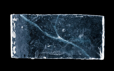 Blue-toned rectangular ice block, with cracks, isolated on black background. Clipping path included