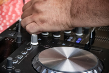 Dick Jockey equipment at the night club, CD turntable and mixing equipment, speakers and amplifiers. Hands of DJ over the turntable in the night club