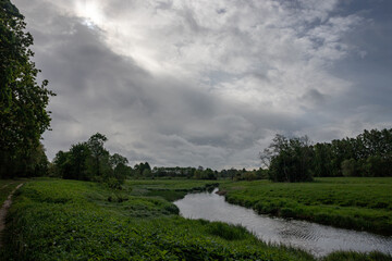 Svēte river runs through meadow near Jelgava town, Latvia, beautiful cloudscape
