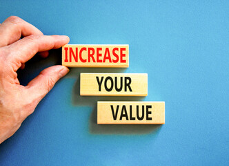 Increase your value symbol. Concept words Increase your value on wooden blocks on a beautiful blue table blue background. Businessman hand. Business increase your value concept. Copy space.