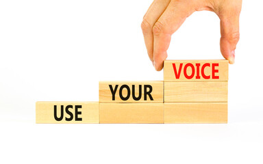 Use your voice symbol. Concept words Use your voice on wooden blocks on a beautiful white table white background. Businessman hand. Business and use your voice concept. Copy space.