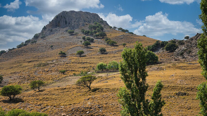 landscape of an imposing volcanic mountain and sky cloud with various trees on the slope of the valley, Imbros Island, Gokceada, Canakkale Turkey