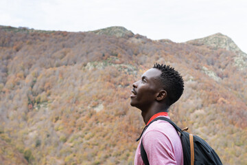 Fototapeta premium Profile of a black-skinned man breathing fresh air at the top of the peak in the Montseny natural park in Barcelona (Spain).