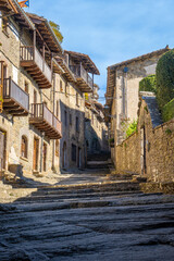 View from below of beautiful street with stairs of a medieval old town in Catalonia in Rupit with lights and shadows