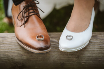 Wedding rings on the shoes of bride and groom - 548316935