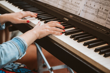Detail view of female hand playing on a keyboard - 548319166