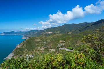 The sea and the landscape of the Cinque Terre, one of the most famous and visited areas in all of Italy, during a sunny day in early autumn, near the town of Riomaggiore, Italy - October 2022.