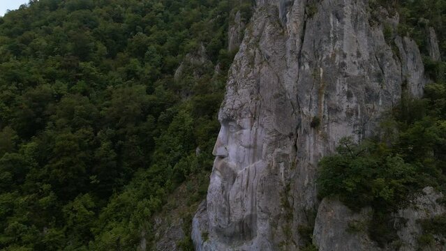 Aerial video of the statue of Decebal, located on the gorges of Danube river in Romania. Video was shoot from a drone with camera lowered with the statue in the view.