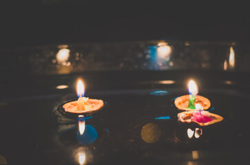 symbolic christmas tradition with candles in nutshell floating on water,